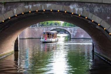 A ship sails under a bridge in Amsterdam, Netherlands