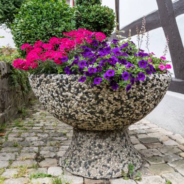 Ortaçağ şehrinin kaldırımında çiçekli büyük saksı