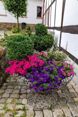 Ortaçağ şehrinin kaldırımında çiçekli büyük saksı
