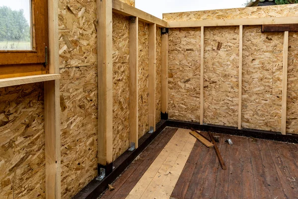 Construction of a garden wooden house, view from the inside, walls from oriented strand board