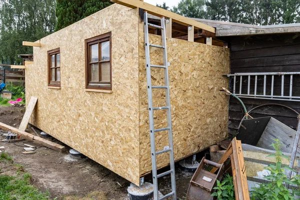 Construction of a garden wooden house, view from the outside, walls from oriented strand board