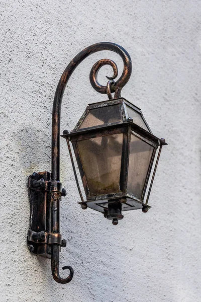 stock image A vintage street lamp is attached to a gray wall covered with decorative plaster