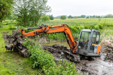 Sazlıklarla kaplanmış alüvyonlu bir gölü kazıcı temizler.