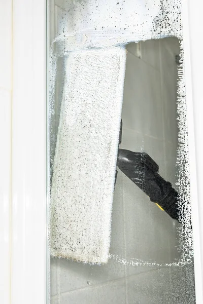一名妇女用蒸汽发生器擦拭淋浴房的玻璃表面 在家里打扫卫生 — 图库照片