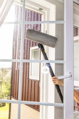 Pencerenin cam yüzeyini buhar jeneratörü fırçasıyla yıkamak, evi temizlemek.