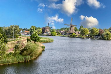 Weesp, Hollanda 'daki kanal kıyısında tarihi ahşap yel değirmeni