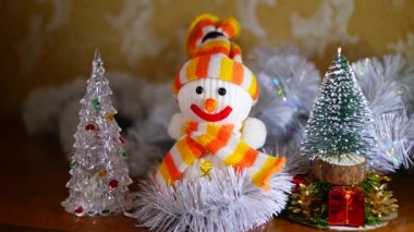 Noel Kardan Adam oyuncağı. Parlak tatil ışıklarının zemininde topları olan süslü bir Noel ağacının yakın çekimi. Akıllı bir kardan adamın yakın çekimi. Noel süslerinin ayrıntıları