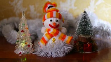 Noel Kardan Adam oyuncağı. Parlak tatil ışıklarının zemininde topları olan süslü bir Noel ağacının yakın çekimi. Akıllı bir kardan adamın yakın çekimi. Noel süslerinin ayrıntıları