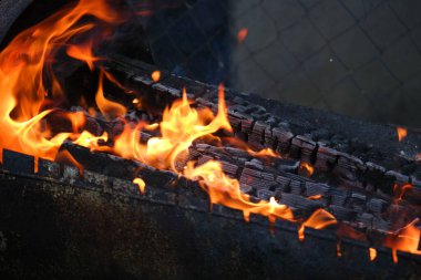 Yanan odun ve kağıt. Yakacak odun yanıyor. Ateş dilleri. turuncu alev. Şenlik. Odun ateşinde pişirme. Yakacak odun barbekü yapmak için yanıyor.