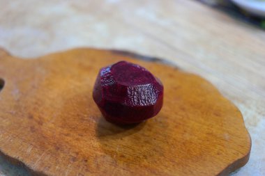 Kırmızı pancar dilimleri. Pancar kesiyorum. Masada taze kırmızı pancar kesen bir kadın, yakın plan. Pancar dilimi yakın plan. Pancar parçalarının arka planı. Pancar. Pancar dilimi izole edilmiş. Puanlı kırmızı pancarlar,