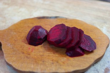 Kırmızı pancar dilimleri. Pancar kesiyorum. Masada taze kırmızı pancar kesen bir kadın, yakın plan. Pancar dilimi yakın plan. Pancar parçalarının arka planı. Pancar. Pancar dilimi izole edilmiş. Puanlı kırmızı pancarlar,