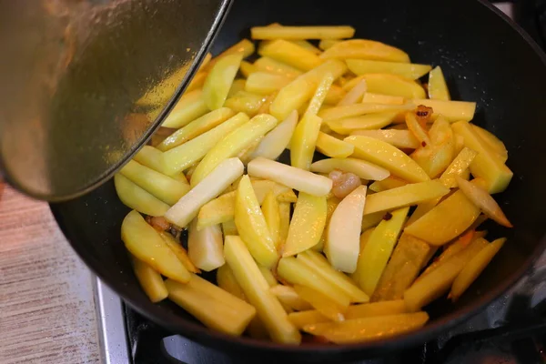 fried potatoes in a pan. Frying fresh potatoes in a frying pan with sunflower oil. Fried potatoes in a frying pan. View of cooker with frying pan filled with fried potatoes