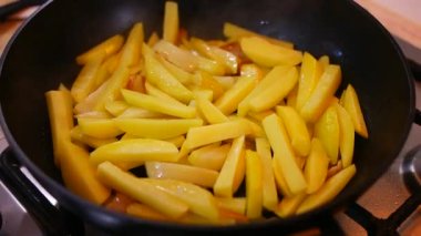 Tavada kızarmış patates. Kızartma tavasında taze patates ve ayçiçeği yağı. Kızartma tavasında patates kızartması. Kızarmış patatesle dolu tavalı fırın manzarası