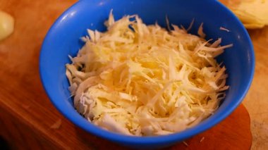 Soğan doğrama. Ahşap tahtanın soğanını bıçakla kesen şefin elleri. Yemek hazırlığı. Sağlıklı beslenme ve yaşam tarzı. Adam beyaz soğanı bıçakla kesiyor. Ev mutfağı. Yemek pişirme.