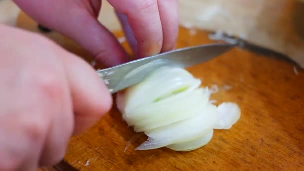 タマネギの切断 板の上に玉ねぎを切るナイフでシェフの手 調理の準備 健康的な食事とライフスタイル ナイフで白玉ねぎを切る男 家庭用キッチン — ストック動画