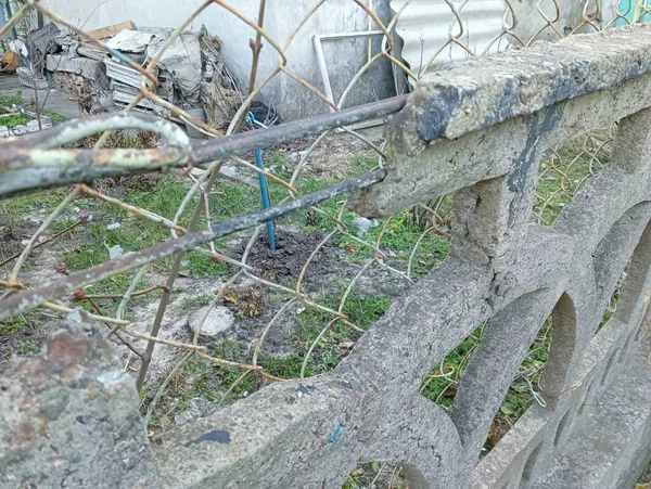 stock image old concrete fence. reinforced concrete fence. A fragment of a concrete fence for the front garden, close-up. An openwork section of a concrete fence with a geometric pattern.Flowerbed fencing