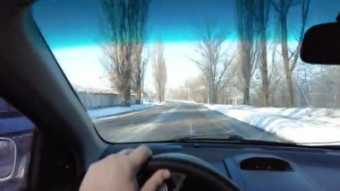 Arabanın içinde. Kötü bir yolda araba kullanmak. Asfaltta delikler var. Şoför kullanıyor. Birinci şahıs görüşü. Yolculuk. Bulutlu bir günde trafikte sürücü kötü hava koşullarında fırtına sırasında