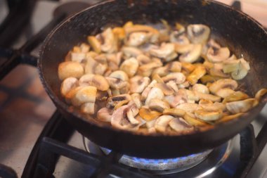 Tavada kızarmış mantar. Kızarmış mantar. Ev mutfağı. Kızarmış mantar, şampiyonlar doğranmış yeşil dereotu serpiştirilir. Ev mutfağı. Seçici odaklanma. Doğranmış mantarlara yakın çekim,