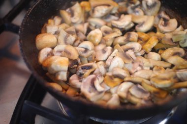 Tavada kızarmış mantar. Kızarmış mantar. Ev mutfağı. Kızarmış mantar, şampiyonlar doğranmış yeşil dereotu serpiştirilir. Ev mutfağı. Seçici odaklanma. Doğranmış mantarlara yakın çekim,