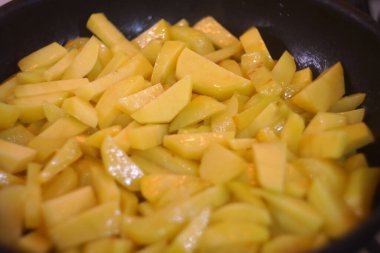 Kızarmış patatesler eski bir tavada. Patates. Ayçiçeği yağında patates kızartması. Patatesleri et ve baharatla iştah açıcı olarak tavada kızartıyorlar. Besleyici ev yemekleri için reçeteler