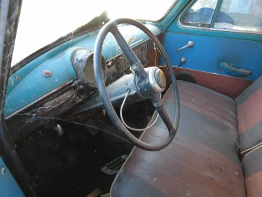 Sovyet eski model bozuk araba. Yeşil çimenlikteki kırık paslı arabaların sabit kamera görüntüleri. Kamera eski arabalarda hareket ediyor. Terk edilmiş, paslı, eski, boyalı bir araba.,