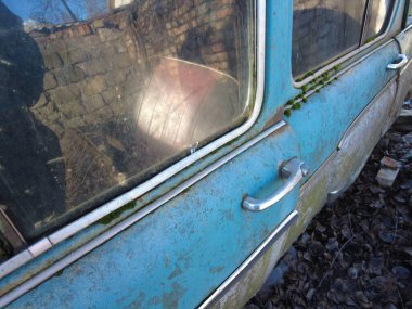 Sovyet eski model bozuk araba. Yeşil çimenlikteki kırık paslı arabaların sabit kamera görüntüleri. Kamera eski arabalarda hareket ediyor. Terk edilmiş, paslı, eski, boyalı bir araba.,