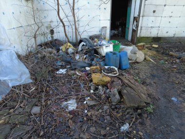 Ukrayna 'da terk edilmiş bir ev. Bahçedeki çöpler. Evi yıktı. İnşaat alanı. İnşaat atıkları. Çöp yığını. Yıkılmış ev. Felaketler binayı yok etti. Çevre kirliliği. 4k görüntü