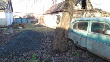 Ukrayna 'da terk edilmiş bir ev. Bahçedeki çöpler. Evi yıktı. İnşaat alanı. İnşaat atıkları. Çöp yığını. Yıkılmış ev. Felaketler binayı yok etti. Çevre kirliliği. 4k fo