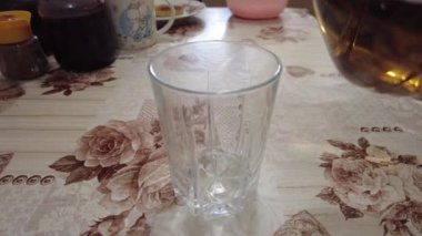 şeffaf bardakta limonata. 4K görüntü. Yakından bir bardağa karbonatlı içecek dolduruyorum. Kola köpüklü, buzlu, şeffaf bardaklı, mavi arka planda köpüklü içecek..