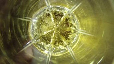 şeffaf bardakta limonata. 4K görüntü. Yakından bir bardağa karbonatlı içecek dolduruyorum. Kola köpüklü, buzlu, şeffaf bardaklı, mavi arka planda köpüklü içecek..