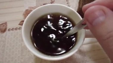 Evde çay yapıyorum. Elektrikli su ısıtıcısından cam bardağa kaynar su dök. Adam evde mutfak masasına sıcak çay döker. Sabah mis kokulu taze siyah çay. 4k görüntü