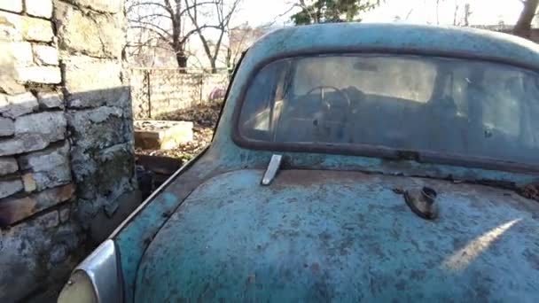 ソ連のレトロな壊れた車 緑の芝生の中で壊れた錆びた車のSteadycamショット カメラは古い車を通って動く ジンバルはUhd 剥がし塗料と錆びたヴィンテージカーを放棄 — ストック動画