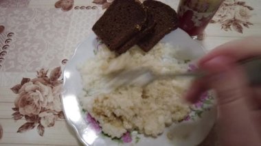Tabakta pirinç lapası. Haşlanmış pirinç. Adam pilav yiyor. Yüksek kalite 4K görüntü. Hainanese tavuklu pilav ya da tavuklu pilav - Asya usulü. Kil tencerede pilav, Dolly shot