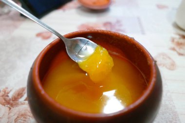 Bal kavanozu. bal ve demir kaşık. Bal karıştırıyorum. kahverengi kil çömlek.