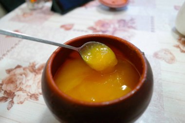 Bal kavanozu. bal ve demir kaşık. Bal karıştırıyorum. kahverengi kil çömlek.