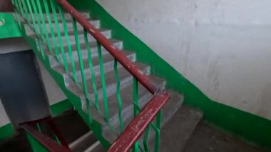 stairs in a multi-storey building. A high-rise concrete staircase tracking a shot. The camera traces the railing of a multistory stairwell. Soviet panel house. Ukrina. Old entrance of the house.