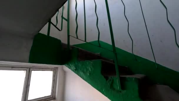 在一座多层楼的楼梯上 一个高层混凝土楼梯跟踪射击 摄像机追踪多层楼梯间的栏杆 苏联的板房乌克丽娜房子的旧入口 — 图库视频影像