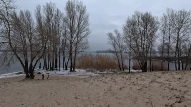 cloudy natural landscape. winter landscape with a river. empty beach in winter. sand and frozen river.