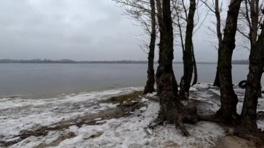 cloudy natural landscape. winter landscape with a river. empty beach in winter. sand and frozen river.