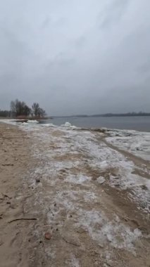 cloudy natural landscape. winter landscape with a river. empty beach in winter. sand and frozen river.