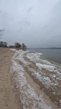 cloudy natural landscape. winter landscape with a river. empty beach in winter. sand and frozen river.