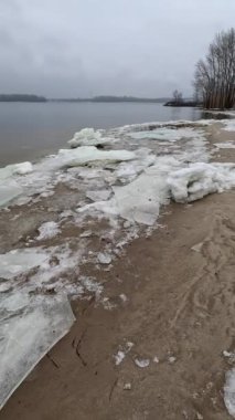 blocks of ice on the shore. big ice floes on the sand. Melting ice. Spring ice drift on the river. Ice close-up. thaw. Melted ice floes on the surface of blue water.