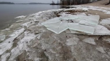 blocks of ice on the shore. big ice floes on the sand. Melting ice. Spring ice drift on the river. Ice close-up. thaw. Melted ice floes on the surface of blue water.