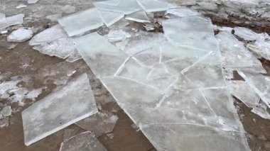 blocks of ice on the shore. big ice floes on the sand. Melting ice. Spring ice drift on the river. Ice close-up. thaw. Melted ice floes on the surface of blue water.