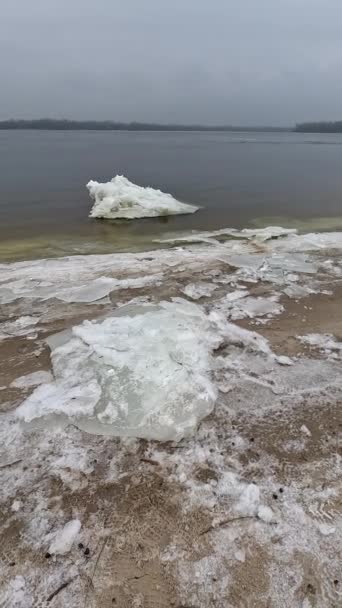 海岸上的冰块 大冰块漂浮在沙滩上 融化的冰 春天的冰在河上漂流 冰上特写解冻 融化的冰漂浮在蓝色的水面上 — 图库视频影像
