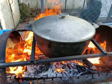 pot on fire. kettle on fire. Cooking on an Open Fire in a Tourist Pot. Cooking at the stake in a tourist bowler hat. Hiking. Tourist pot at bonfire. Large pot on a campfire on a camping trip