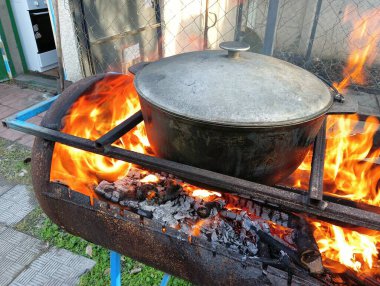 pot on fire. kettle on fire. Cooking on an Open Fire in a Tourist Pot. Cooking at the stake in a tourist bowler hat. Hiking. Tourist pot at bonfire. Large pot on a campfire on a camping trip