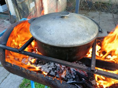 pot on fire. kettle on fire. Cooking on an Open Fire in a Tourist Pot. Cooking at the stake in a tourist bowler hat. Hiking. Tourist pot at bonfire. Large pot on a campfire on a camping trip