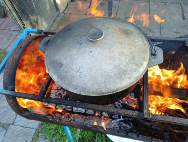 pot on fire. kettle on fire. Cooking on an Open Fire in a Tourist Pot. Cooking at the stake in a tourist bowler hat. Hiking. Tourist pot at bonfire. Large pot on a campfire on a camping trip