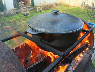 pot on fire. kettle on fire. Cooking on an Open Fire in a Tourist Pot. Cooking at the stake in a tourist bowler hat. Hiking. Tourist pot at bonfire. Large pot on a campfire on a camping trip